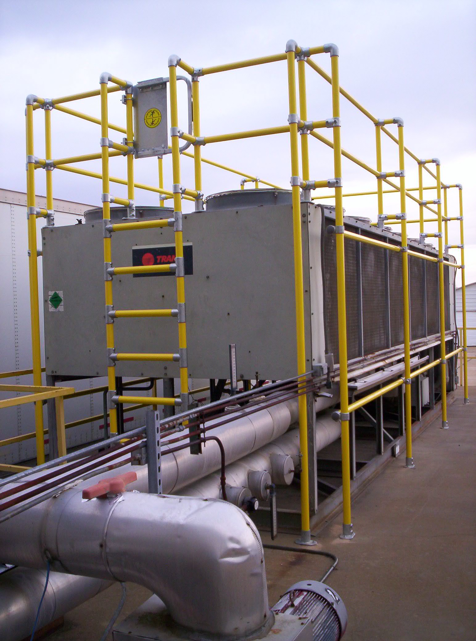 EquipGuard yellow guardrail mounted around an industrial chiller