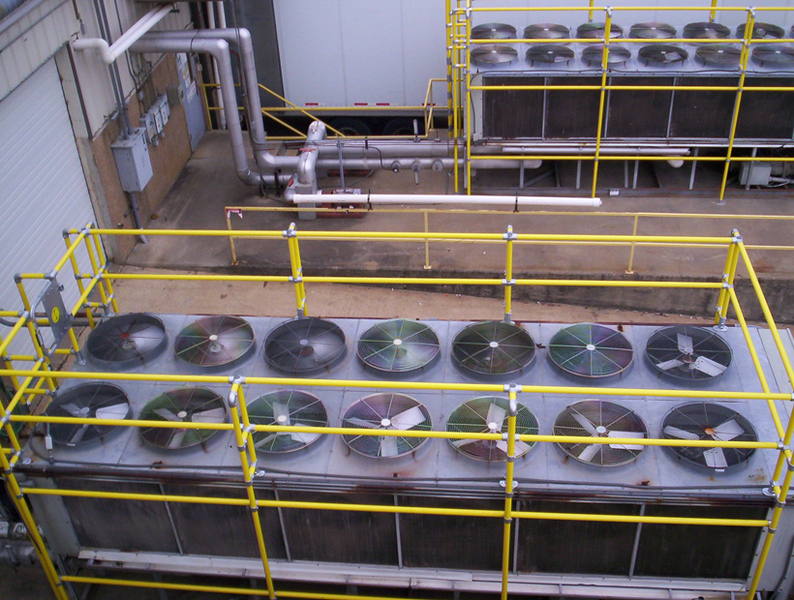 Multiple industrial chillers protected by yellow EquipGuard guardrail